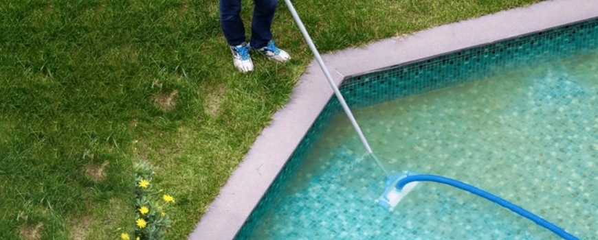 homem a aspirar a piscina com aspirador hidraulico