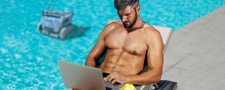 homem a trabalhar no computador ao lado da piscina